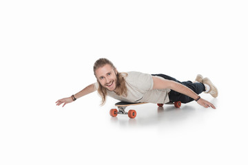 Wall Mural - excited young man lying on longboard isolated on white