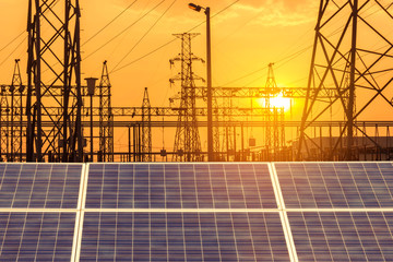 Wall Mural - solar cells in power station with high voltage electric pillars substation on sunset.