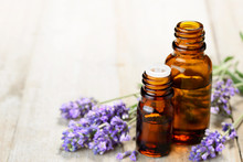 Lavender Essential Oil In The Amber Bottle, On The Wooden Table
