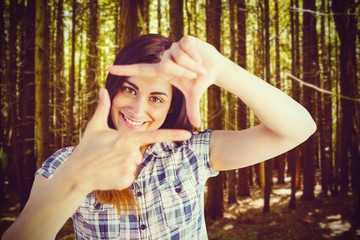 Sticker - Composite image of portrait of woman looking through hands 