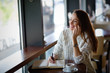 © NDABCREATIVITY - Beautiful woman drinking coffee in restaurant alone