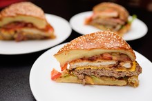Appetizing Slices Of A Large Burger Or Meat Pie Closeup.On The Table In The Restaurant