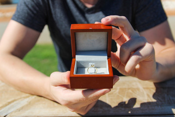 men hands hold a velvet box with Diamond ring