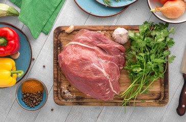 Poster - Fresh beef tenderloin with different vegetables on wooden table