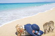 Beach accessories in the sand. Hat, sunglasses, bag and flip flops on beach. Holiday and summer concept.
