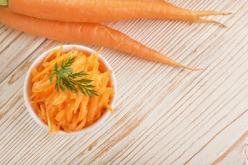 Wall Mural - grated carrot on wooden background