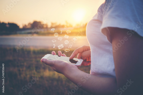 Fotografía Woman Using smart phone emitting holographic image of social media