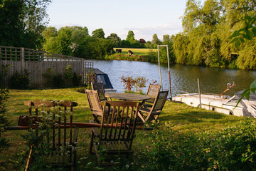 Countryside landscape. River and boat. Patio furniture