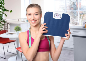 Sticker - Diet concept. Young beautiful woman holding scales on white background