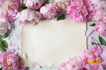  Pink peonies on a wooden background and a paper blank sheet