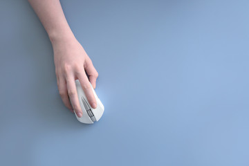 Canvas Print - Female hand holding computer mouse on grey background