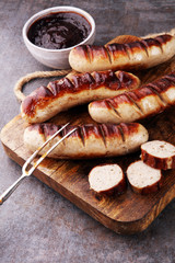 Wall Mural - Grilled sausages with sauce ketchup on a wooden table - Home-made Pork Sausages