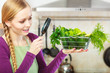 © Voyagerix - Woman looking through magnifier at vegetables basket