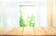 © hakinmhan - Empty of wood table top on blur of curtain window and abstract green from garden with sunlight .For montage product display or key visual layout