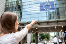 Woman Pointing With Hand On The European Flag On The Parliament Building In Brussel