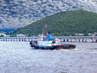 Tug boat is sailing to berth after completed assist vessel to alongside.