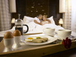© eskay lim - couple in hotel room with breakfast ready for them