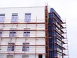 Malerarbeiten -  Baugerüst umhüllt Fassade eines Wohnhauses