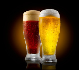 Wall Mural - Craft beer. Two glasses of cold light and dark beer isolated on black background