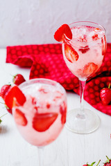 Wall Mural - Alcoholic and non-alcoholic refreshing drinks, cold sparkling cocktail with ice and fresh strawberries in a beautiful glass on a light background 