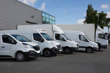 Wall Mural - White Delivery Trucks Backed Up to A Warehouse Building