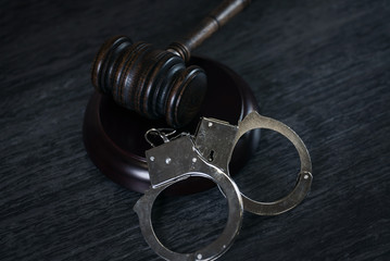 Poster - Handcuffs and gavel on dark rustic table