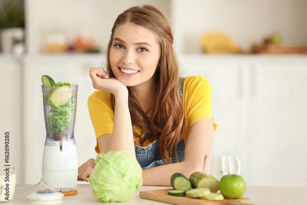 Weight loss concept. Beautiful young woman preparing green smoothie in kitchen