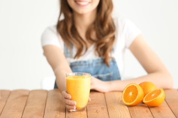 Wall Mural - Weight loss concept. Beautiful young woman sitting at table with healthy delicious smoothie on white background