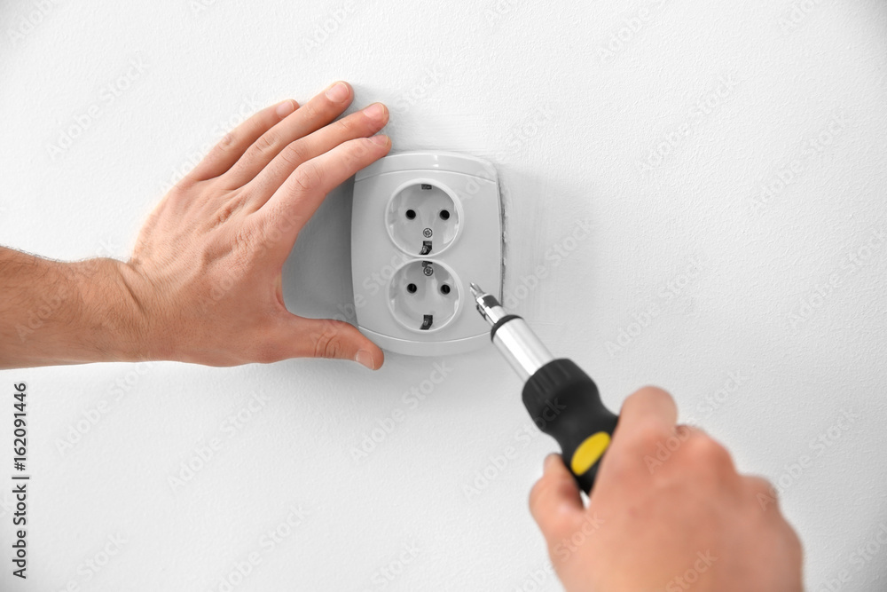 Electrician repairing socket, closeup