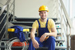 © Africa Studio - Young smiling electrician sitting on stairs indoors