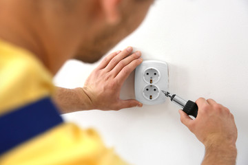 Wall Mural - Electrician repairing socket, closeup