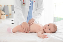 Doctor Examining Little Baby In Clinic. Baby Health Concept