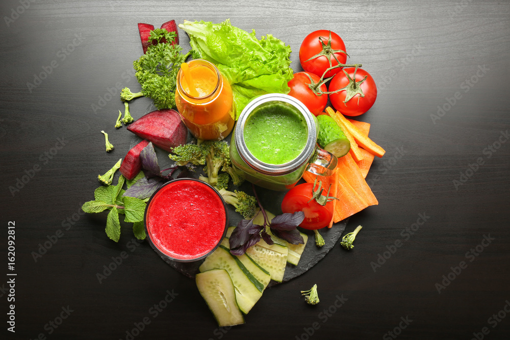 Fresh smoothies and vegetables on table