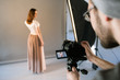 © Photodrive - POV of photographer during studio session. Screen of professional camera with portrait of model on it. Fashion photoshoot backstage