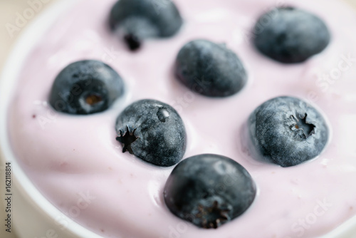 Plakat jogurt jagodowy organiczny w misce na stole