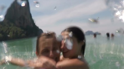 Wall Mural - couple kissing and spinning in water on sea pov, young man and woman tourists in love on summer seas