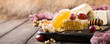 Honeycomb with assorted cheeses, grape and walnuts on old wooden cutting board. Healthy food concept. Copy space.
