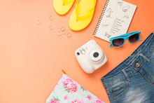 Summer Traveling Concept. Vacation Accessories On Orange Background.
