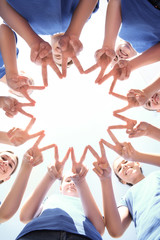 Canvas Print - Team of volunteers putting their hands together as symbol of unity, bottom view