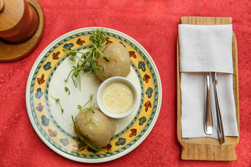 National Lithuanian dish - Zeppelin with sauce on a colored plate. Top view