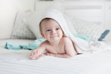 9 Months Old Baby Lying Under White Towel On Bed