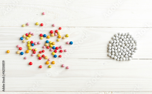 Fotografía Chaotic colorful balls and organized white balls