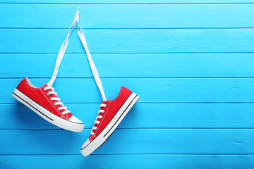 Wall Mural - Pair of red sneakers on blue wooden table