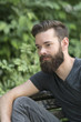 © cineberg - Thoughtful bearded guy sitting on a bench in park