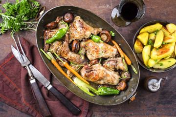 Rabbit with vegetable and mushrooms as top view in a stewpot