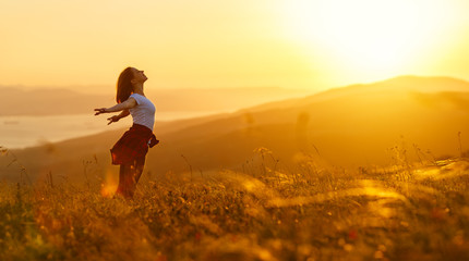 Poster - Happy woman   on the sunset in nature in summer with open hands
