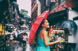 People lifestyle umbrella travel Asian woman shopping in chinatown market street. Rainy day girl tourist under red oriental umbrella in back alleys in Shanghai, China.
