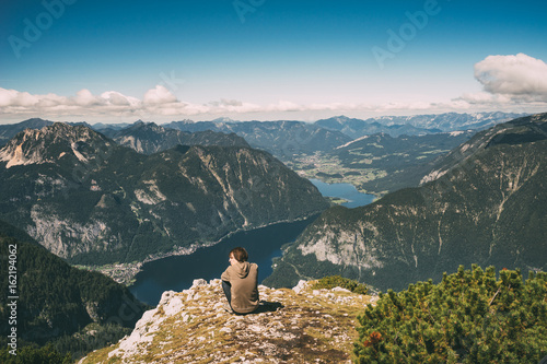 Photographie Young man relaxing on the edge of mountain and enjoying wonderful view
