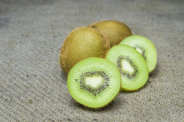 Ripe whole kiwi fruit and half kiwi fruit isolated put on brown sack