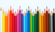 Colored Pencils Row With Wave On White Background.